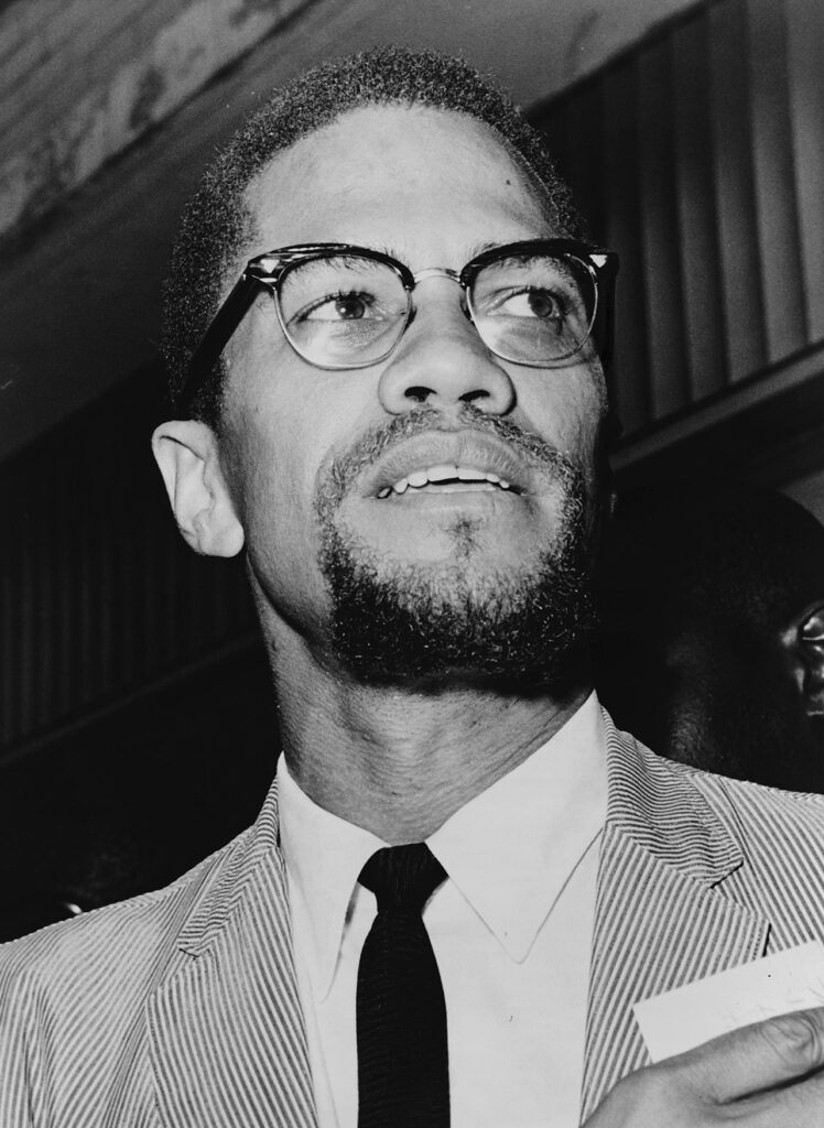 A photo of Malcolm X, a prominent African American civil rights leader, known for his advocacy of black empowerment, self-determination, and his powerful speeches against racial injustice.