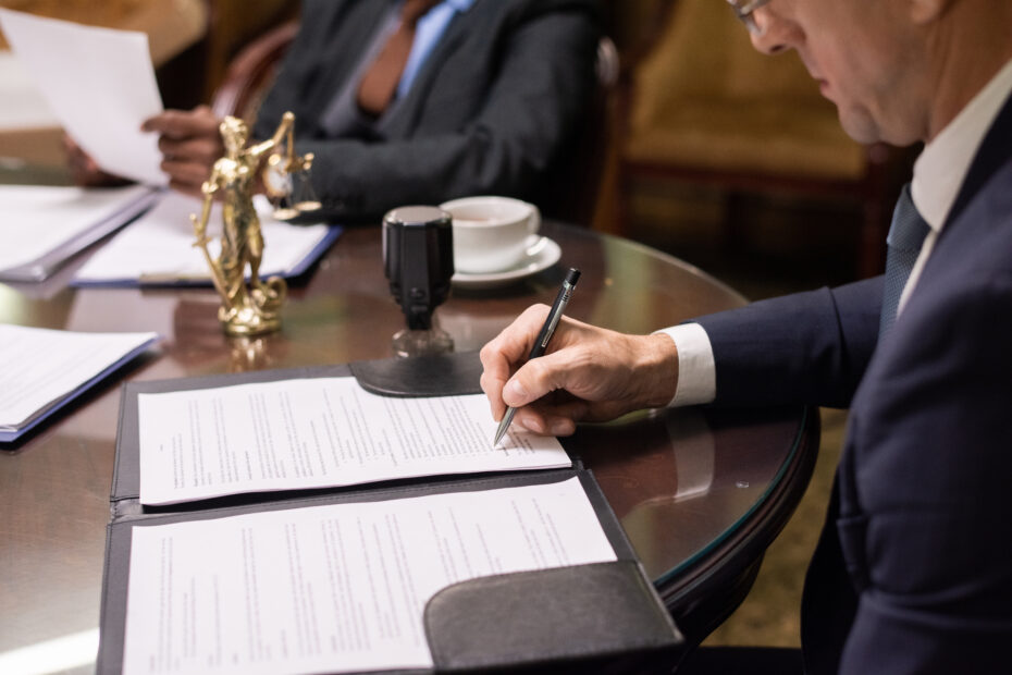 A photo of two businessmen signing official documents to represent the UN charter