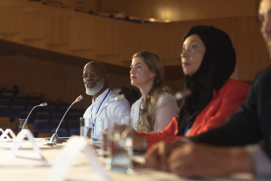 A group of four professionals sitting on a panel in a stadium representing the UN member states