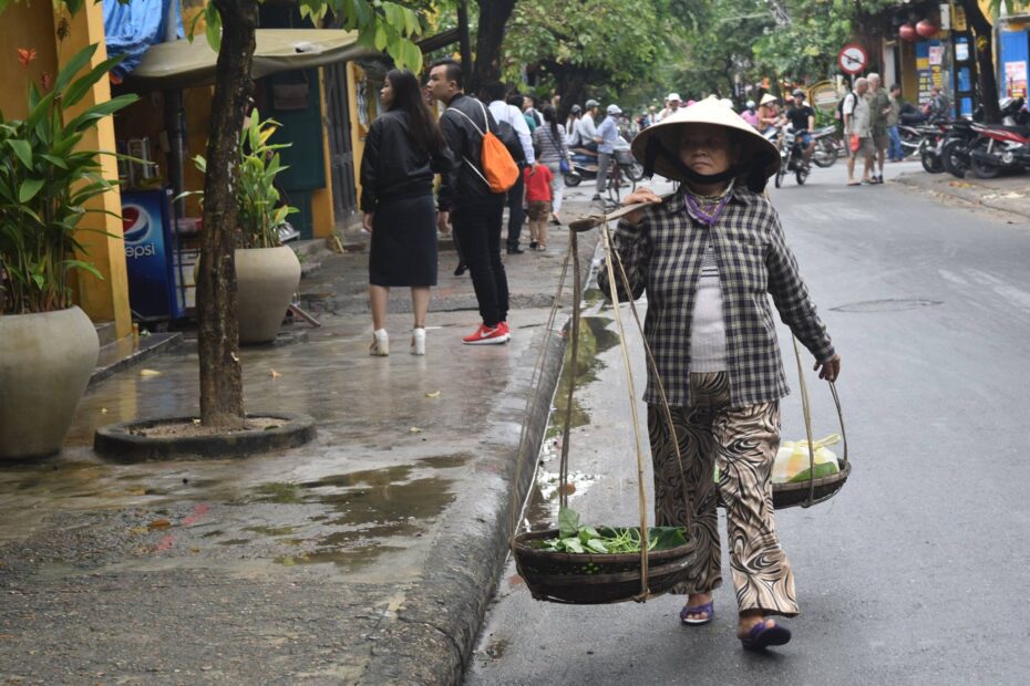 Vietnamese woman walking with food through Vietnam