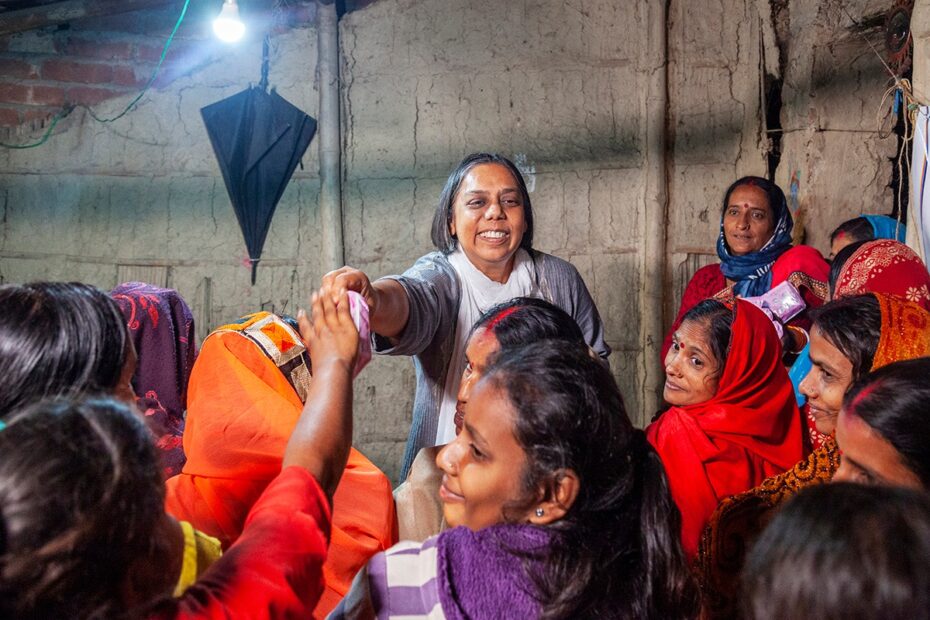 Ruchira Gupta, founder of Apne Aap NGO, distributing supplies to a group of Indian women in India, as part of efforts to combat sex trafficking and support marginalized communities.