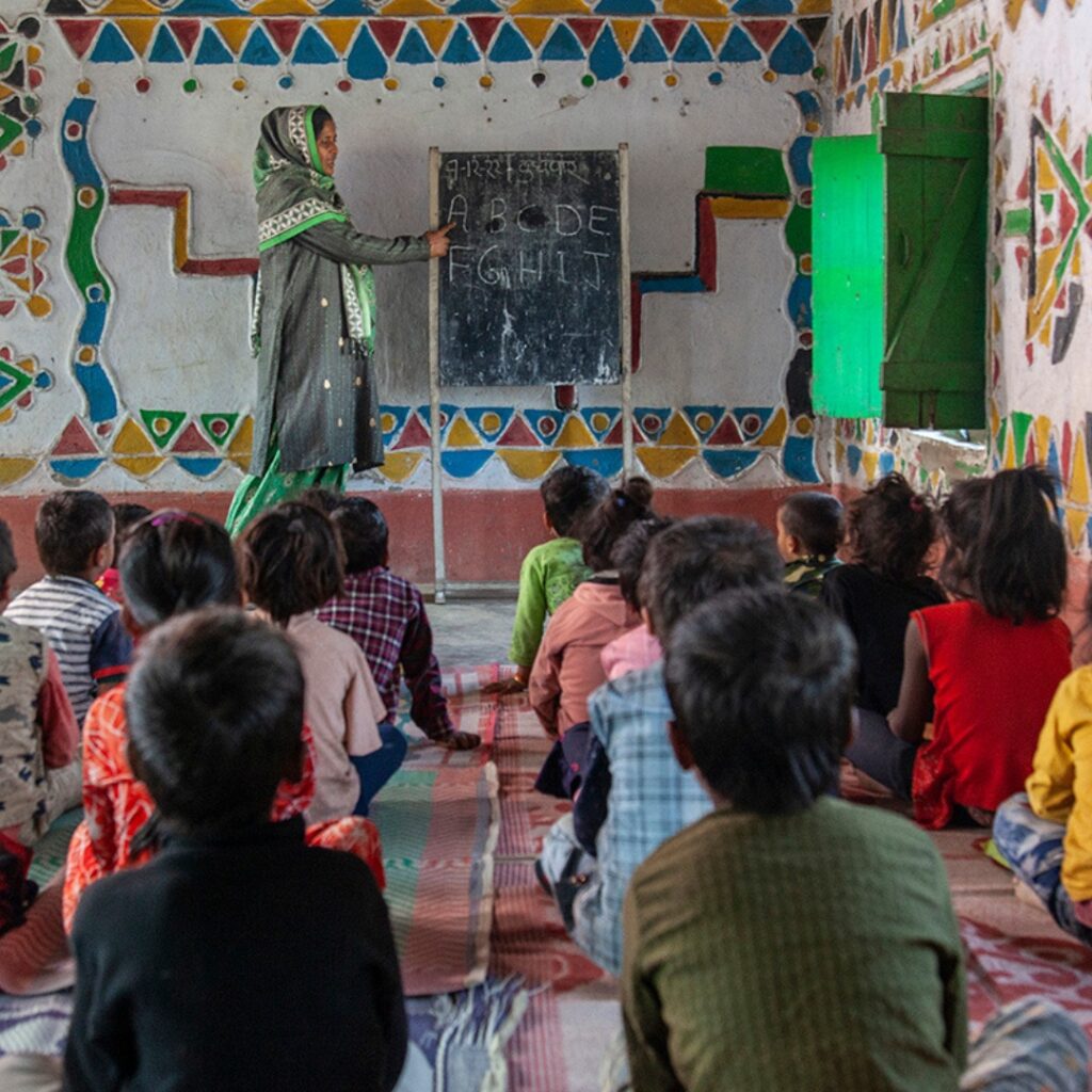 An Indian woman teaching children from Apne Aap NGO in India, an anti-sex trafficking organization supporting marginalized women.