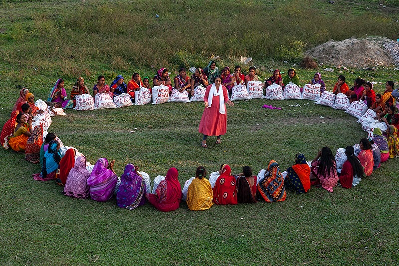 Ruchira Gupta, founder of Apne Aap NGO, distributing food and providing education to a group of Indian women in India, as part of efforts to combat sex trafficking and support marginalized communities.